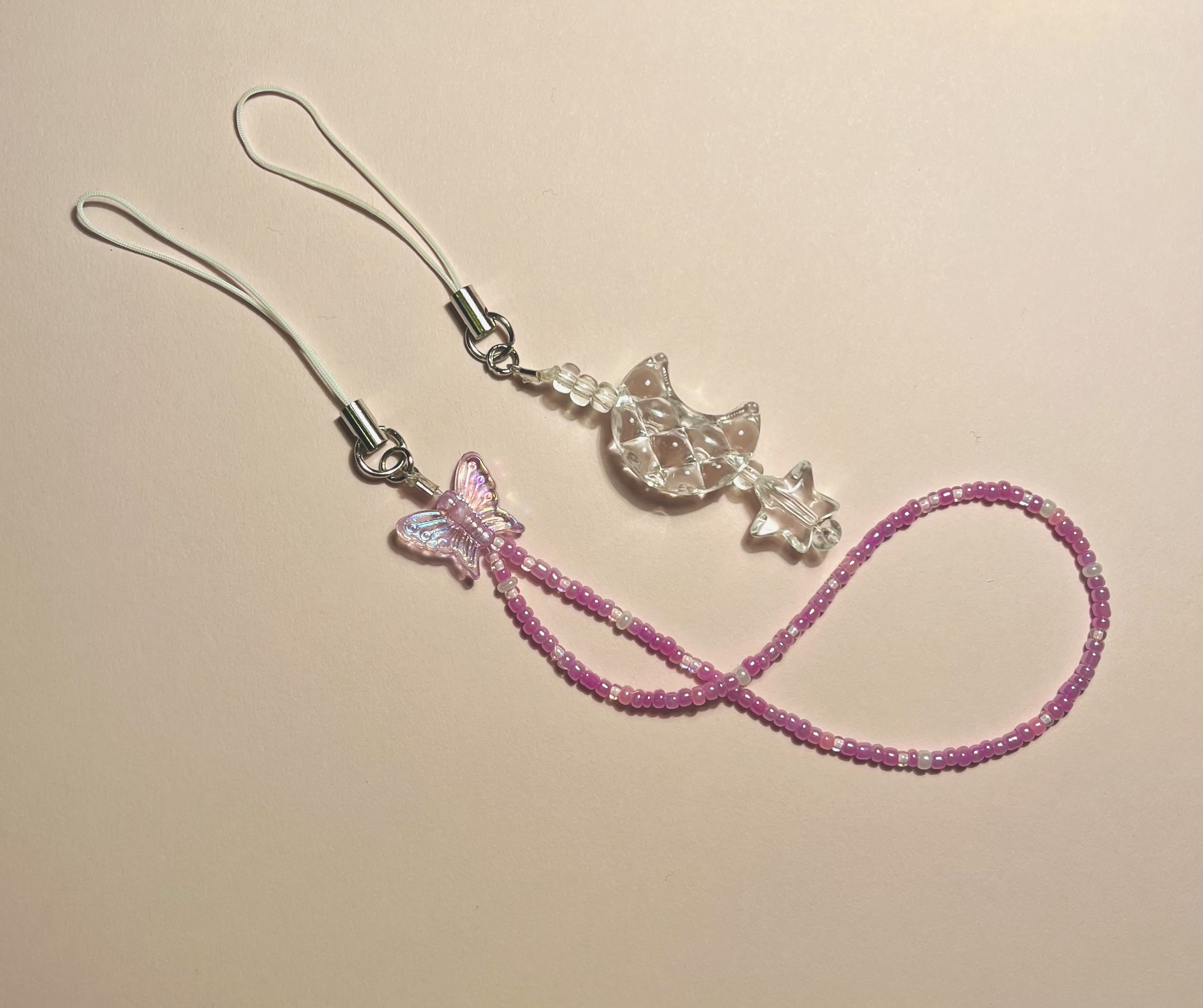 1 clear beads phone charm with a moon and star and 1 purple phone charm with a seed bead loop and butterfly
